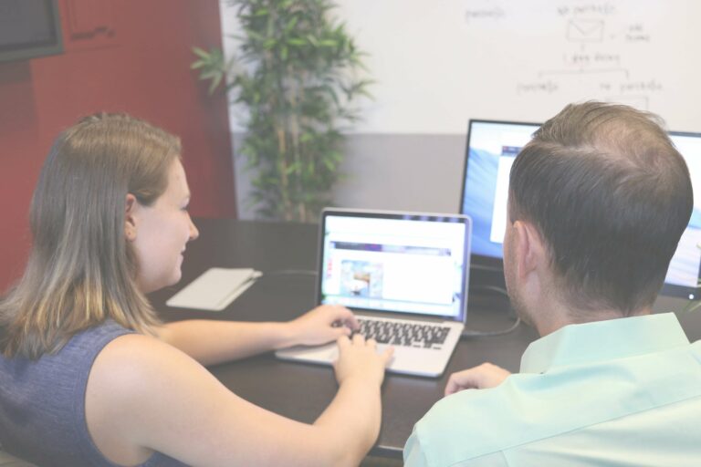 A team member brainstorming and planning website workflow strategies on a glass board.