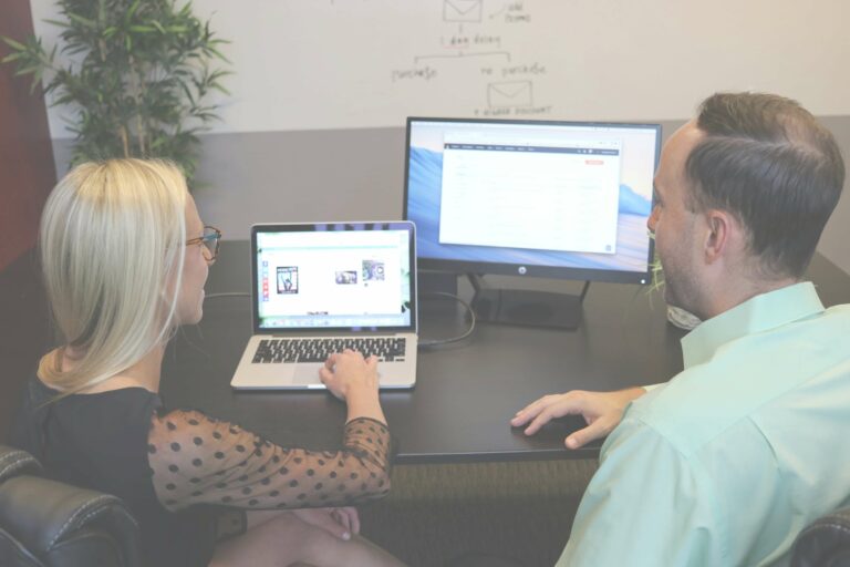 A web designer reviewing a client's website performance metrics on a laptop.