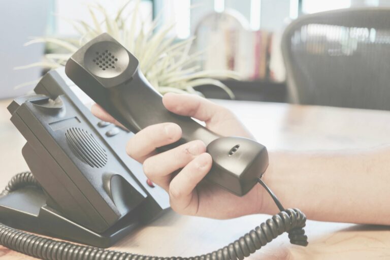 A team member holding a phone, discussing web design improvements with a Westminster client.