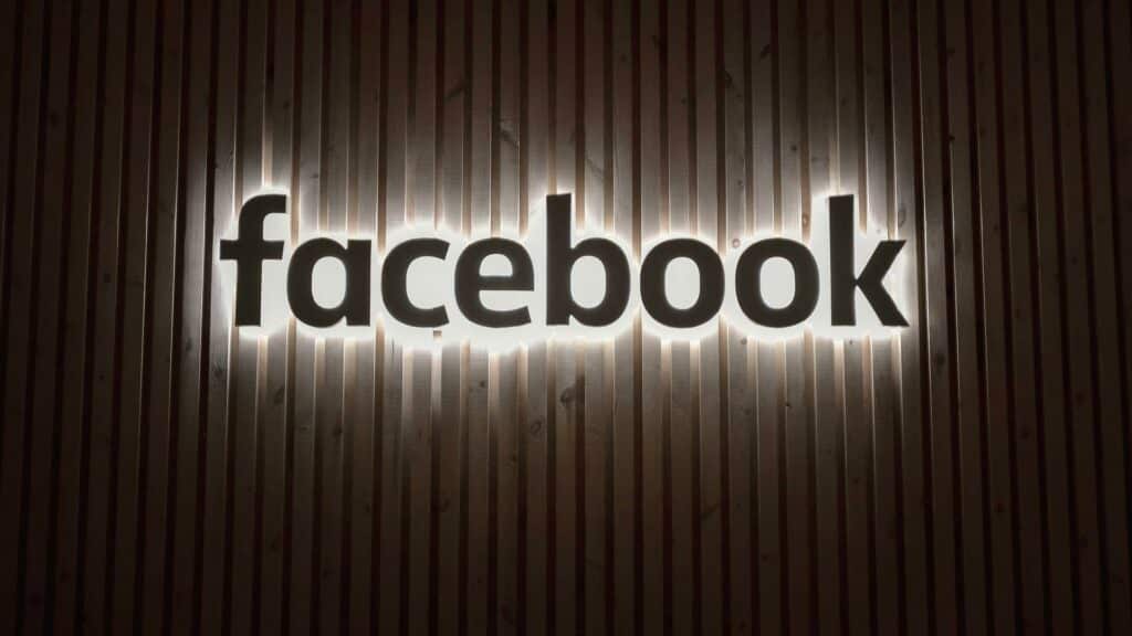 Illuminated Facebook logo on a wooden background