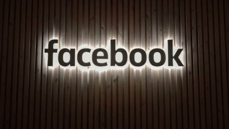 Illuminated Facebook logo on a wooden background