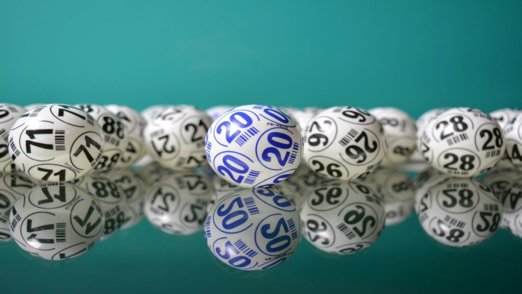 A collection of numbered lottery balls with one blue ball marked 20 standing out.