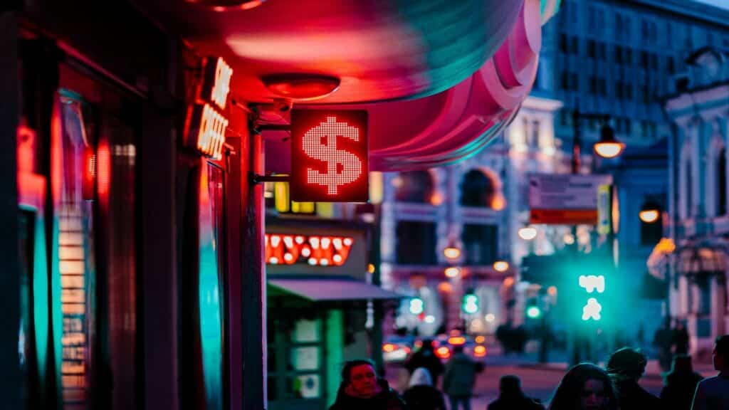 Neon dollar sign in a vibrant cityscape representing effective marketing campaigns