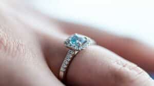 Create engaging content with a stunning engagement ring featuring a blue gemstone and diamond accents