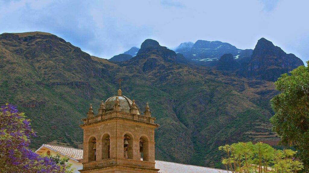 Colonial church bell tower with mountain backdrop in Cusco region