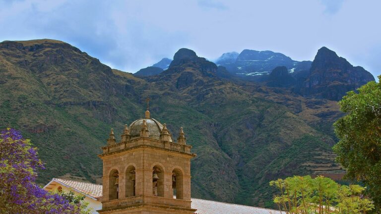 Colonial church bell tower with mountain backdrop in Cusco region