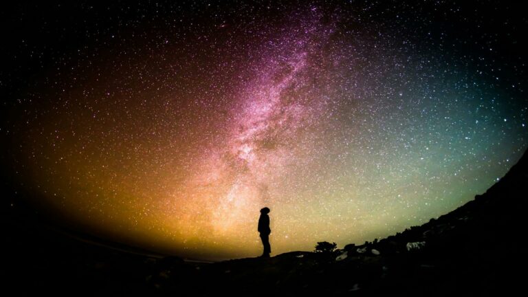 Silhouette of a person gazing at the Milky Way under a starry sky, symbolizing the complexity of search engine algorithms.