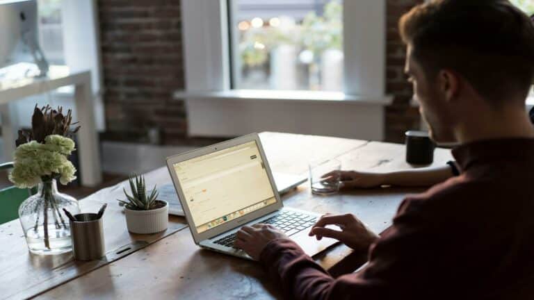 Person working on a laptop in a modern workspace, focusing on optimizing title tags for SEO in web design London