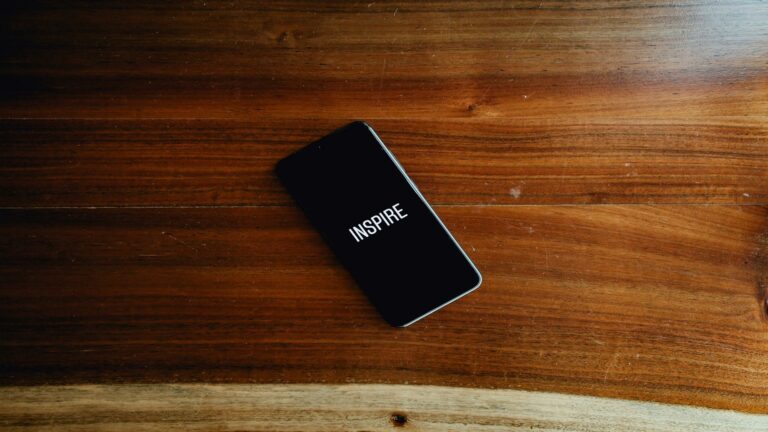 Smartphone displaying the word 'Inspire' on a wooden table, symbolizing effective SEO strategies