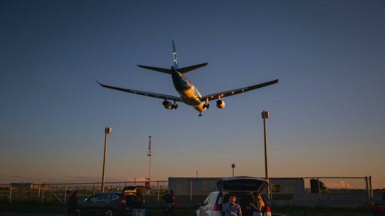 Airplane landing at sunset with people watching, symbolizing the importance of high-quality backlinks in digital strategies.