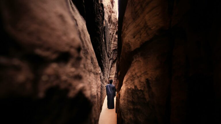 Person walking through narrow rock formations symbolizing focus on local SEO techniques