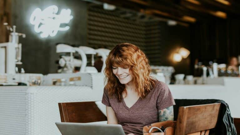 Person working on a laptop in a modern cafe, representing mobile web design