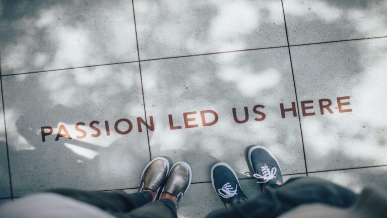 Passion led us here text on pavement with two pairs of shoes, symbolizing social media engagement