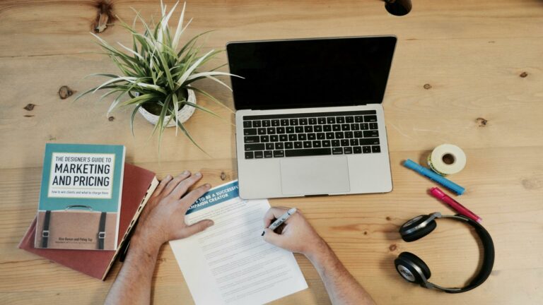 Workspace setup for planning website content strategy with a laptop and marketing materials