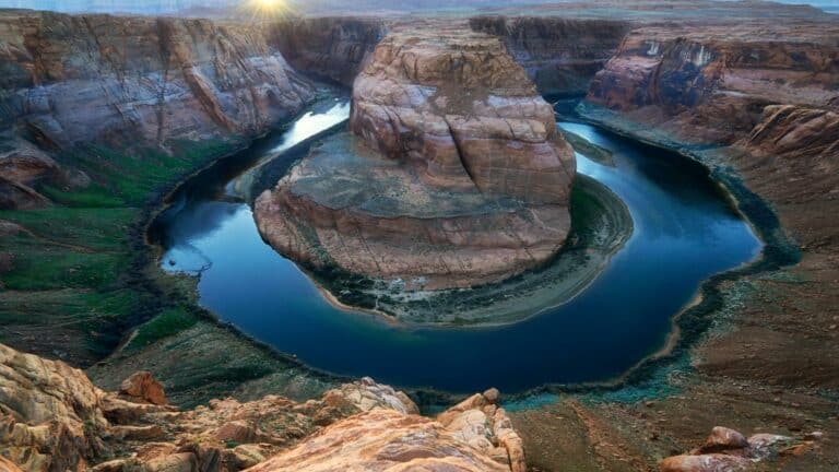 Aerial view of Horseshoe Bend with a river curving around a large rock formation