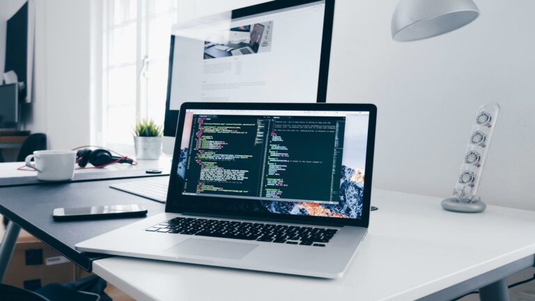 Laptop displaying code with a focus on website security measures, placed on a desk with a clean workspace.