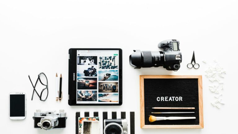 Flat lay of cameras, tablet, and tools representing creative work