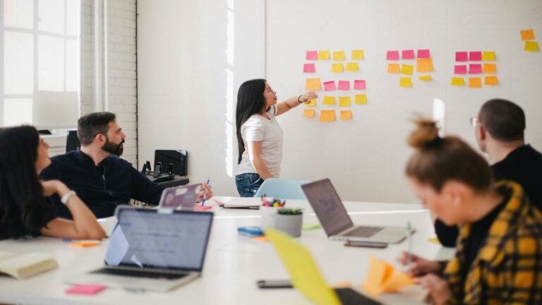 Team brainstorming session with sticky notes on a whiteboard, optimizing strategies for search engine algorithms.