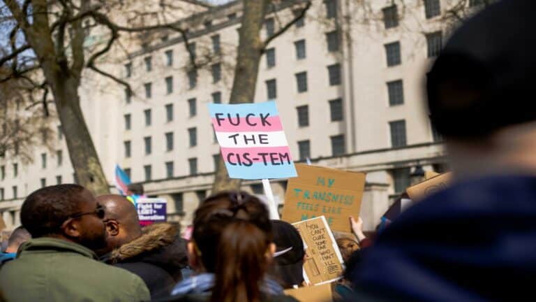 Protesters holding signs advocating inclusivity and equality during a rally, emphasizing the importance of website usability testing.