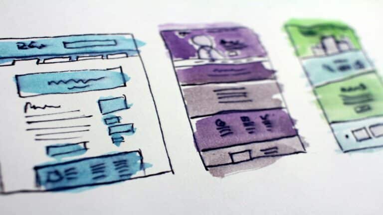 Website content ideas sketched as watercolor wireframes showing layout variations in blue, purple, and green