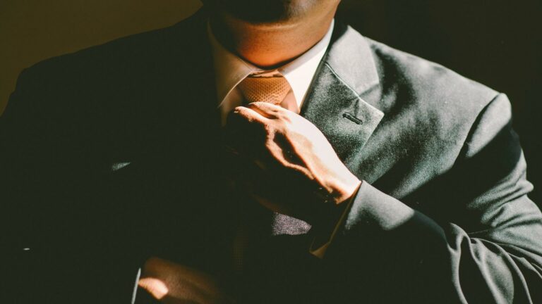 Man adjusting tie in a suit