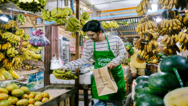 Vendor in a local market selecting bananas to improve user engagement for fresh produce delivery services