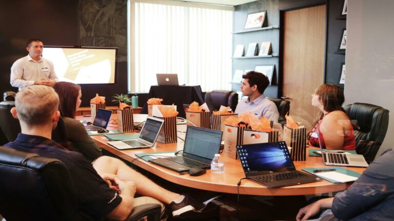 Website redesign tips session with team members collaborating in conference room with laptops and presentation