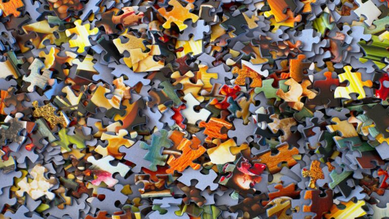 A scattered collection of colorful puzzle pieces symbolizing the complexity of content marketing strategies.