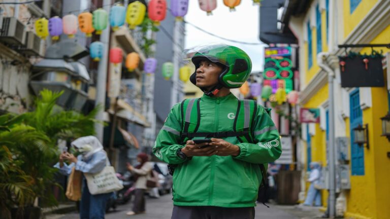 A delivery rider using a mobile app interface in a vibrant urban area, showcasing website user interface integration.