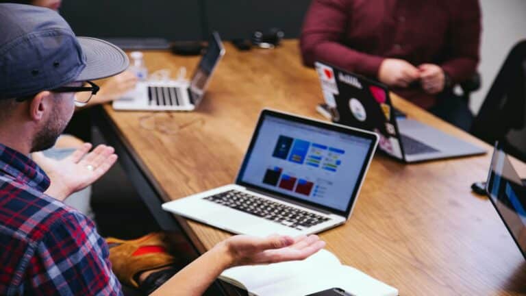 Team discussing web design strategies with laptops in a London-based agency, focusing on optimizing title tags