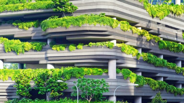 Modern architectural building facade with cascading green plants and layered horizontal design elements