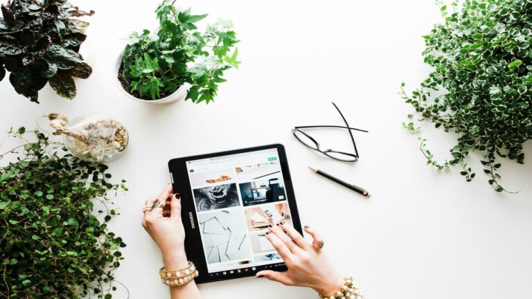 Tablet displaying website analytics on a desk surrounded by plants and accessories