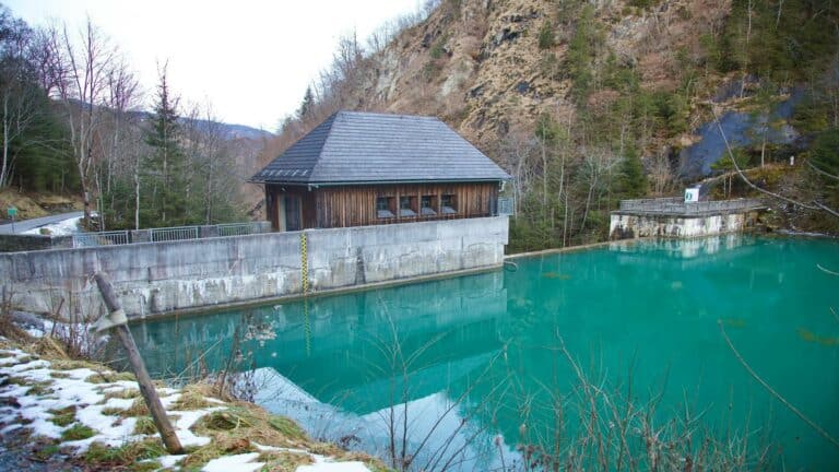 A tranquil dam surrounded by mountains and trees, symbolizing online business growth through stability and sustainability.