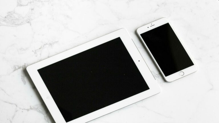 Tablet and smartphone showcasing responsive website design on a marble surface