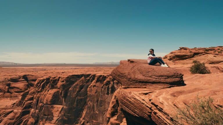 Person sitting on a rock overlooking a canyon