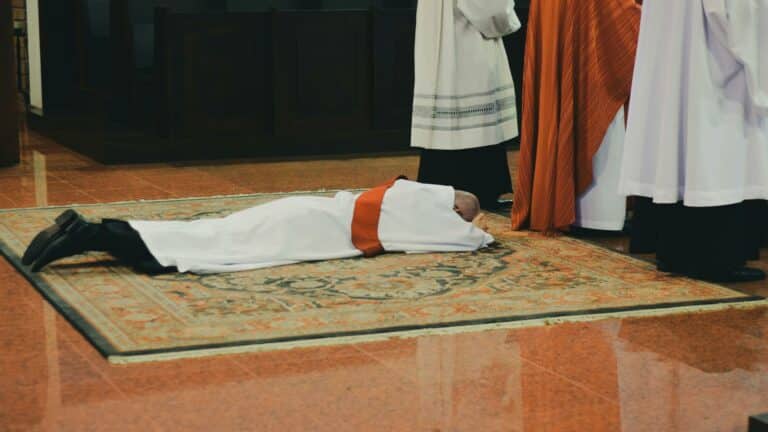 Priest lying prostrate during ordination ceremony, website design company capturing sacred moments