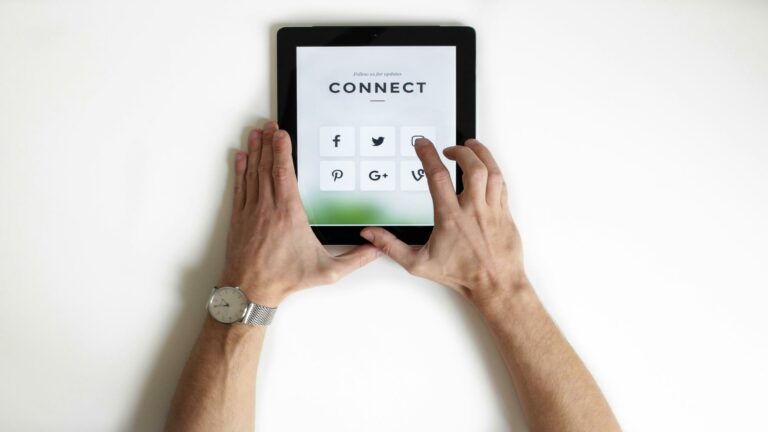 Hands interacting with a tablet displaying social media icons to optimize site structure