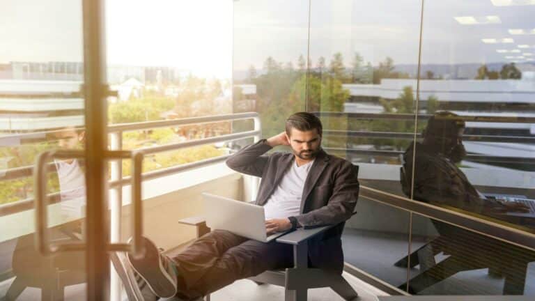 Person sitting on a balcony with a laptop