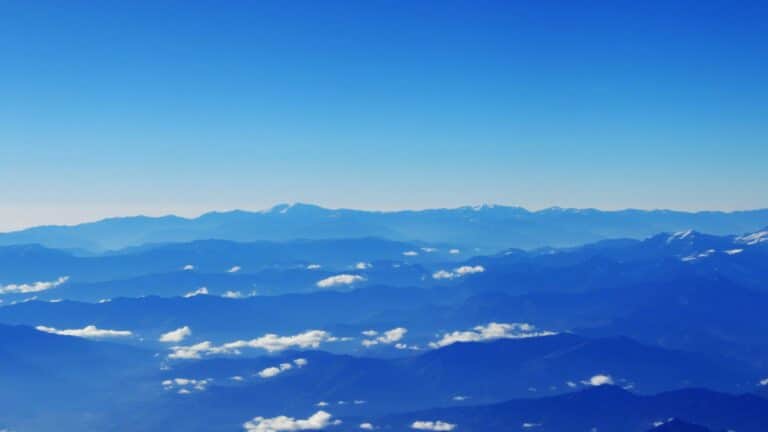 Local SEO services illustrated through majestic blue mountain ranges with scattered clouds viewed from above