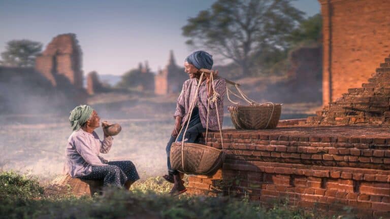 Two women in traditional attire resting with woven baskets in a rural setting to improve bounce rate