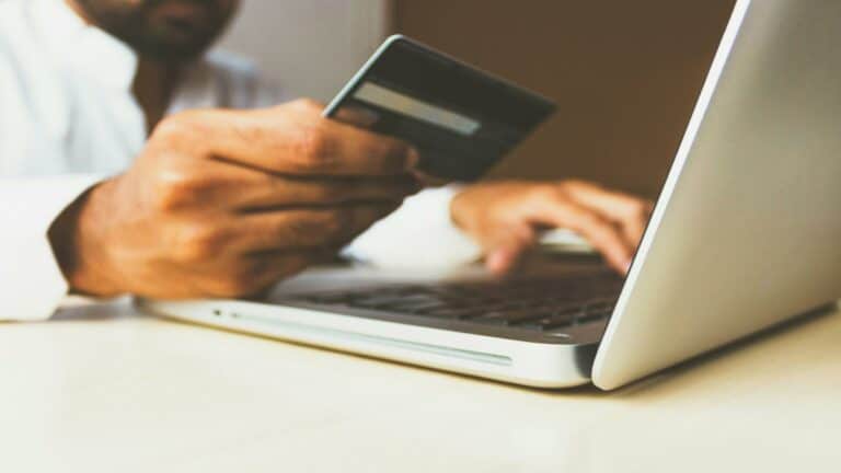 Person using a laptop and credit card, showcasing mobile web design for secure online transactions