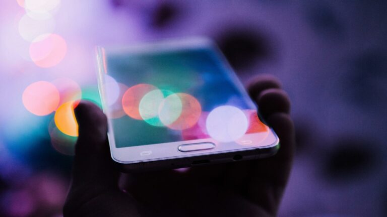 Smartphone displaying responsive website design with vibrant bokeh lights in the background