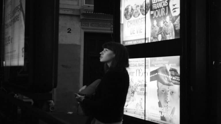 Person standing near illuminated posters showcasing local marketing strategies