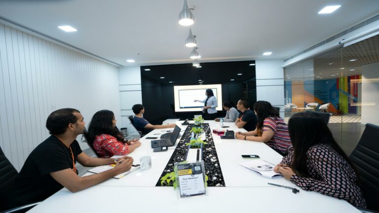 A group of people in a conference room discussing mobile-friendly websites