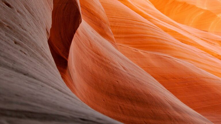 Close-up view of smooth, curved sandstone formations in warm tones