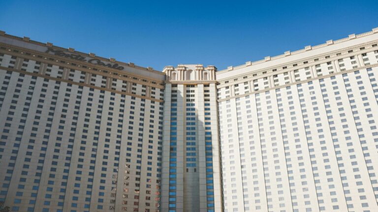 A grand hotel building with symmetrical architecture under a clear blue sky.