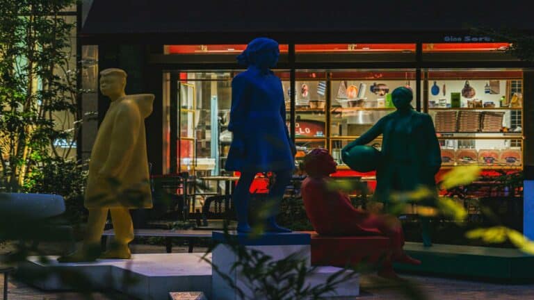 Website design company creative workspace featuring colorful life-sized sculptures outside modern office storefront