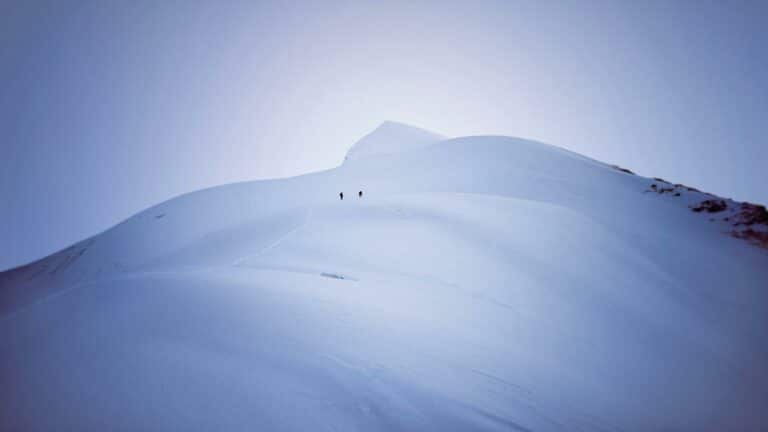 Local SEO services visualization showing two climbers ascending a snow-covered mountain peak, symbolizing the journey to digital success