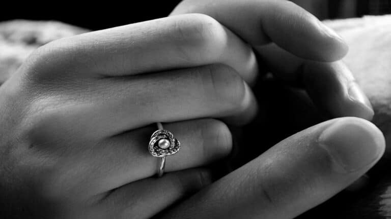 A close-up of hands holding a heart-shaped ring with a pearl, symbolizing creating engaging content