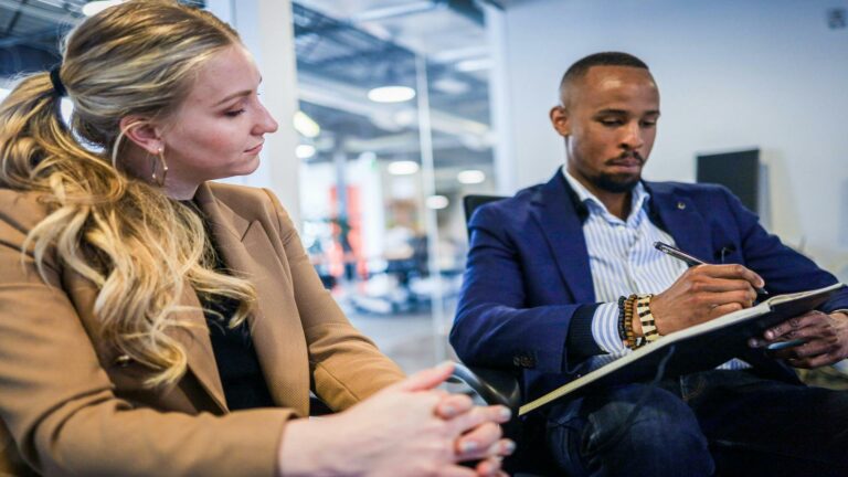 Two professionals discussing digital marketing strategies in a modern office setting